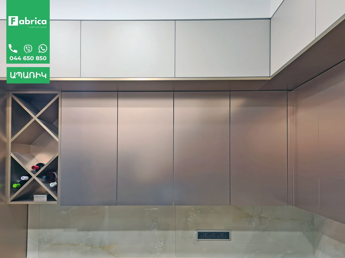 A kitchen with white cabinets and a wine rack
