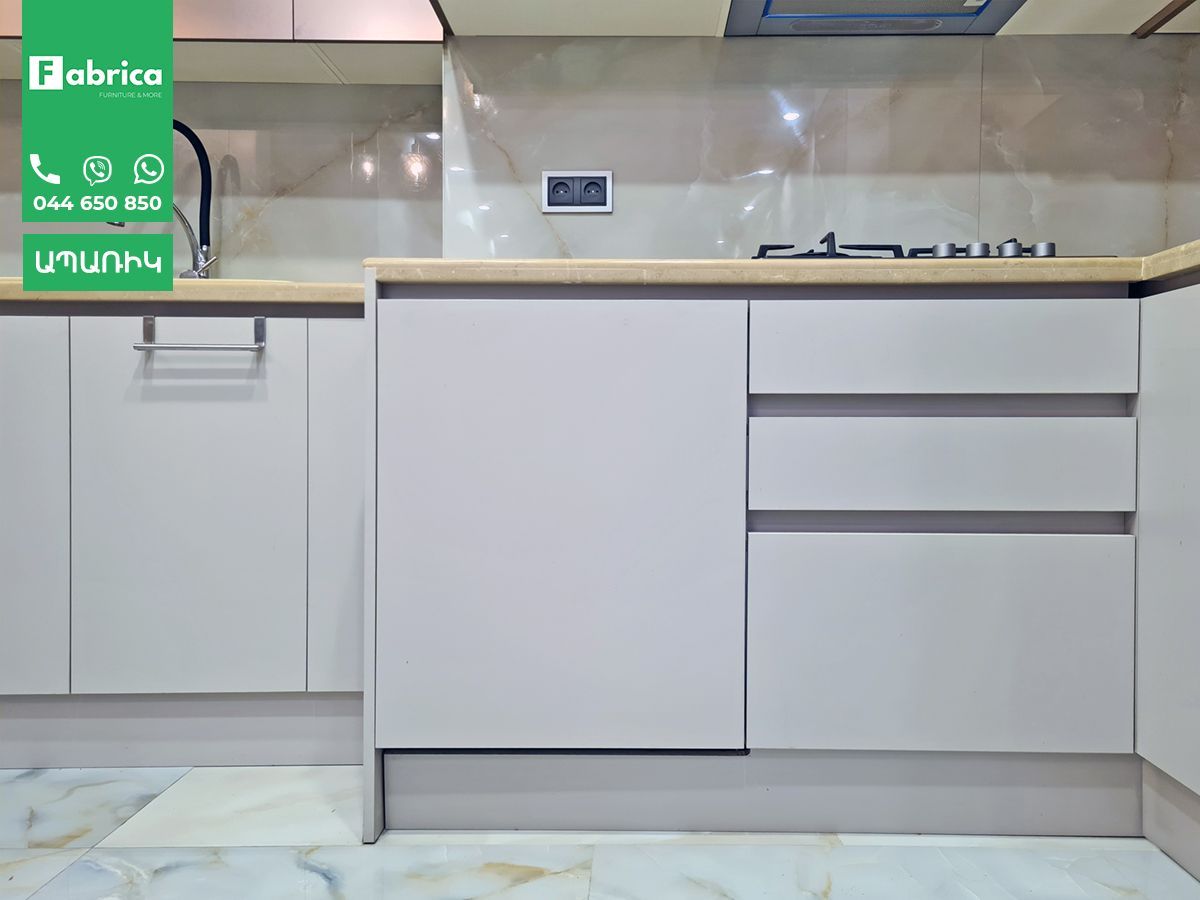 A kitchen with white cabinets and a wooden counter top.