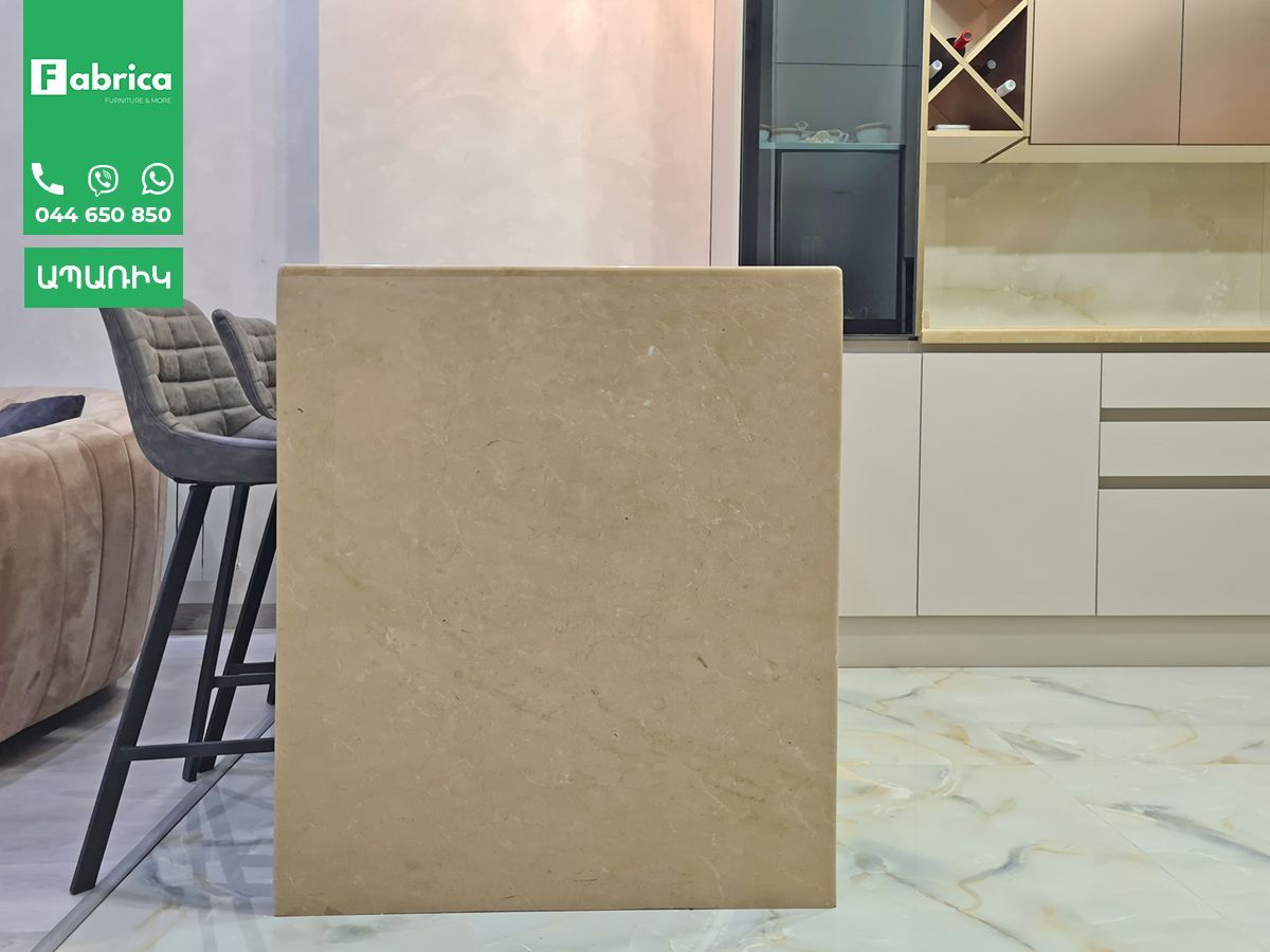 A large piece of wood is sitting in a living room next to a kitchen.