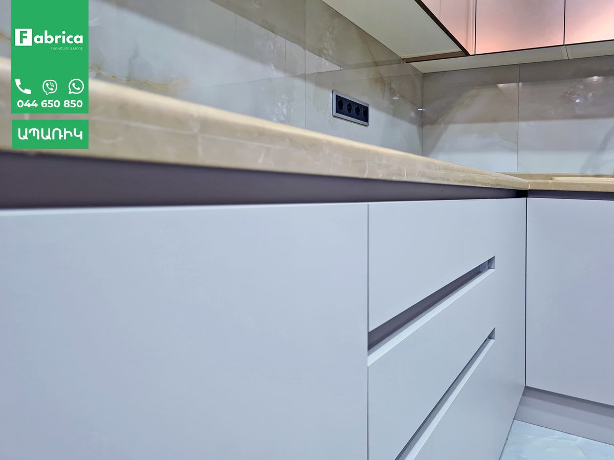 A kitchen with white cabinets and a wooden counter top.