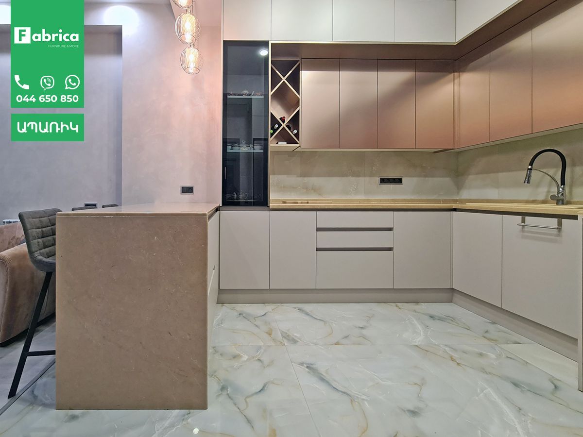 A kitchen with white cabinets and a marble floor.