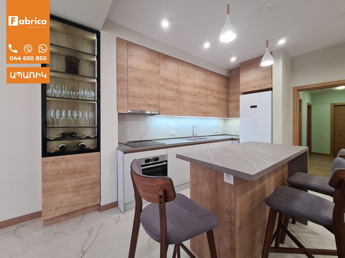 A kitchen with wooden cabinets and a marble counter top.