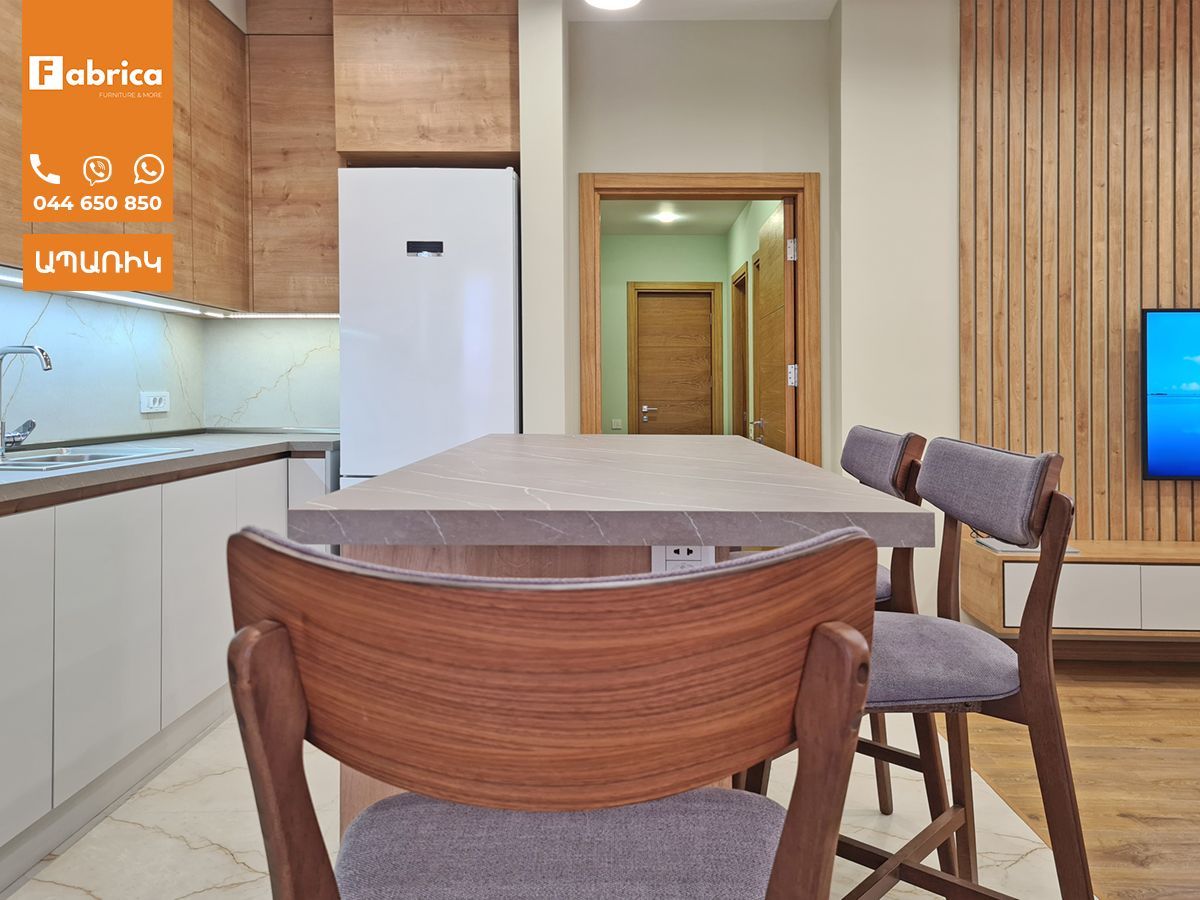 A kitchen with a table and chairs and a television