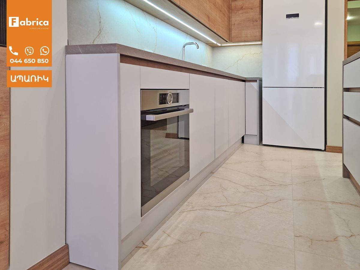 A kitchen with white cabinets and a white refrigerator
