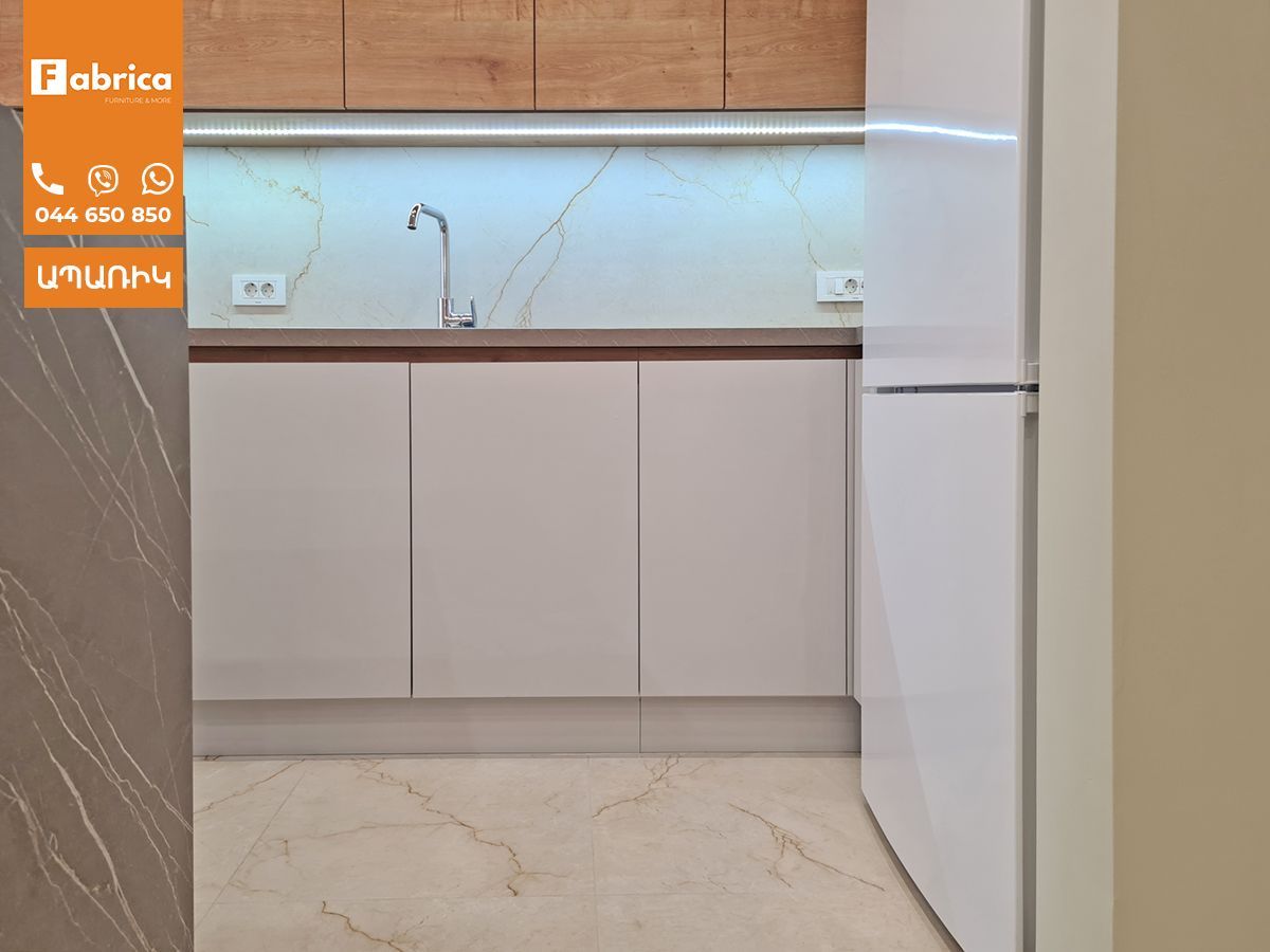 A kitchen with white cabinets and a white refrigerator.