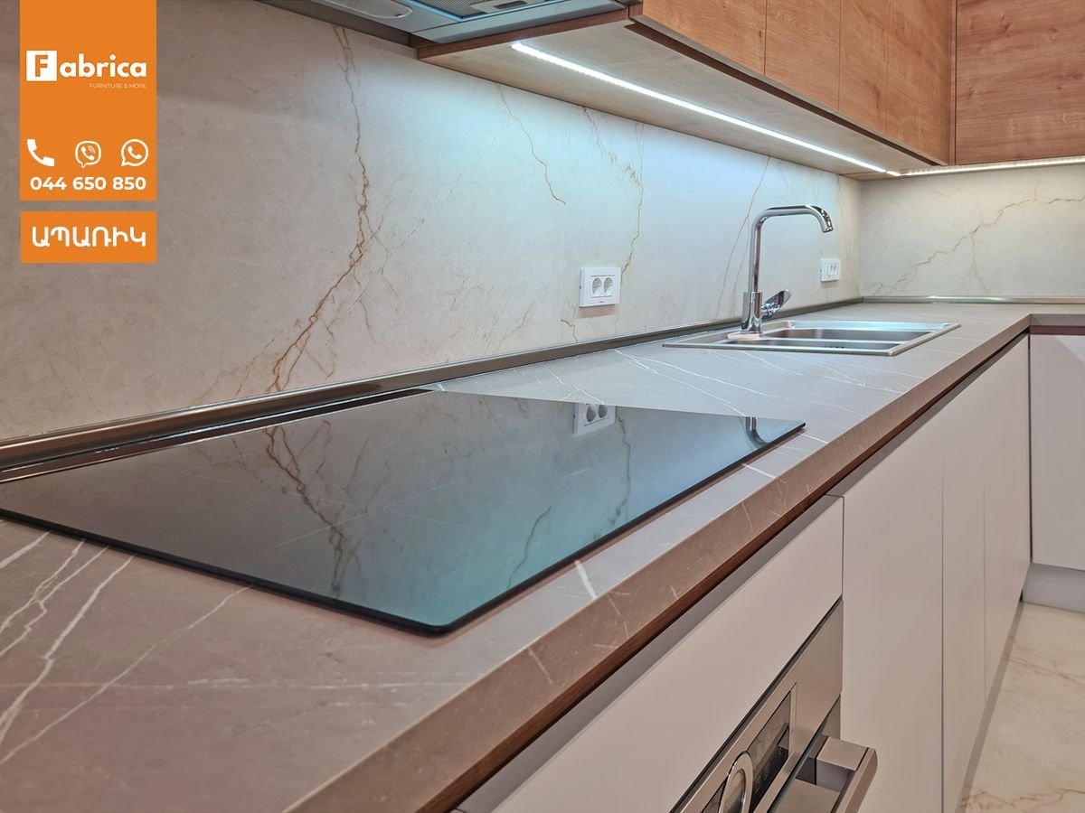 A kitchen with a stove top oven and a sink