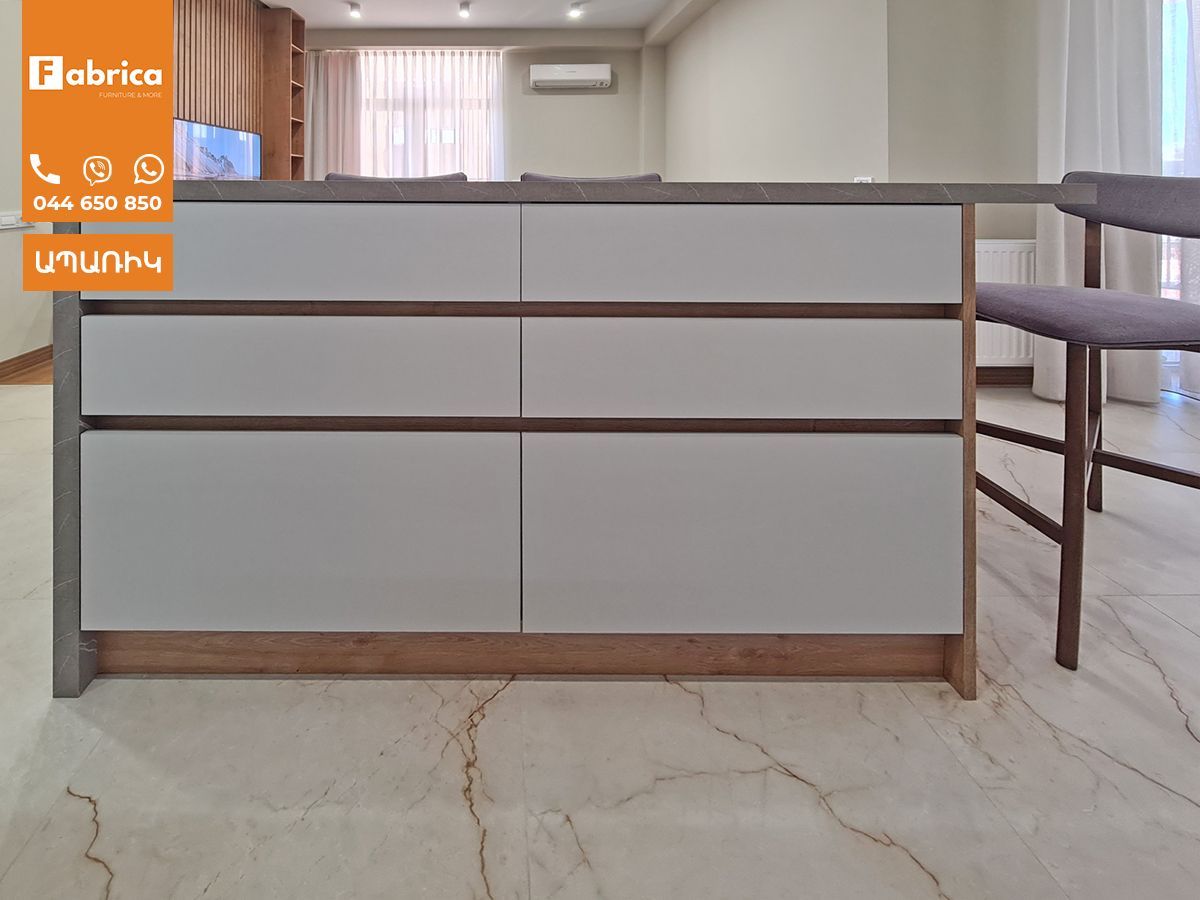 A kitchen with white cabinets and a sign that says fabrico