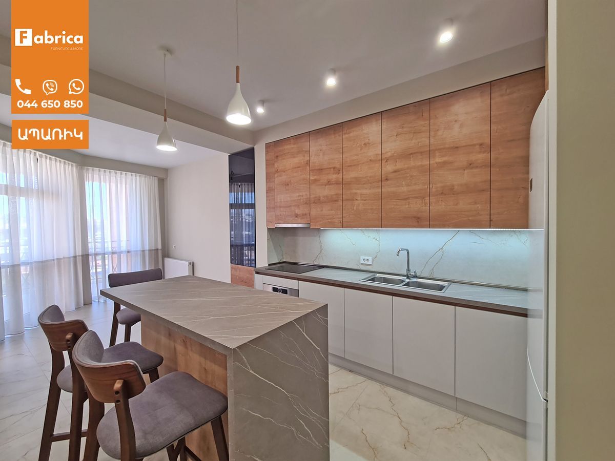 A kitchen with wooden cabinets and a large island.