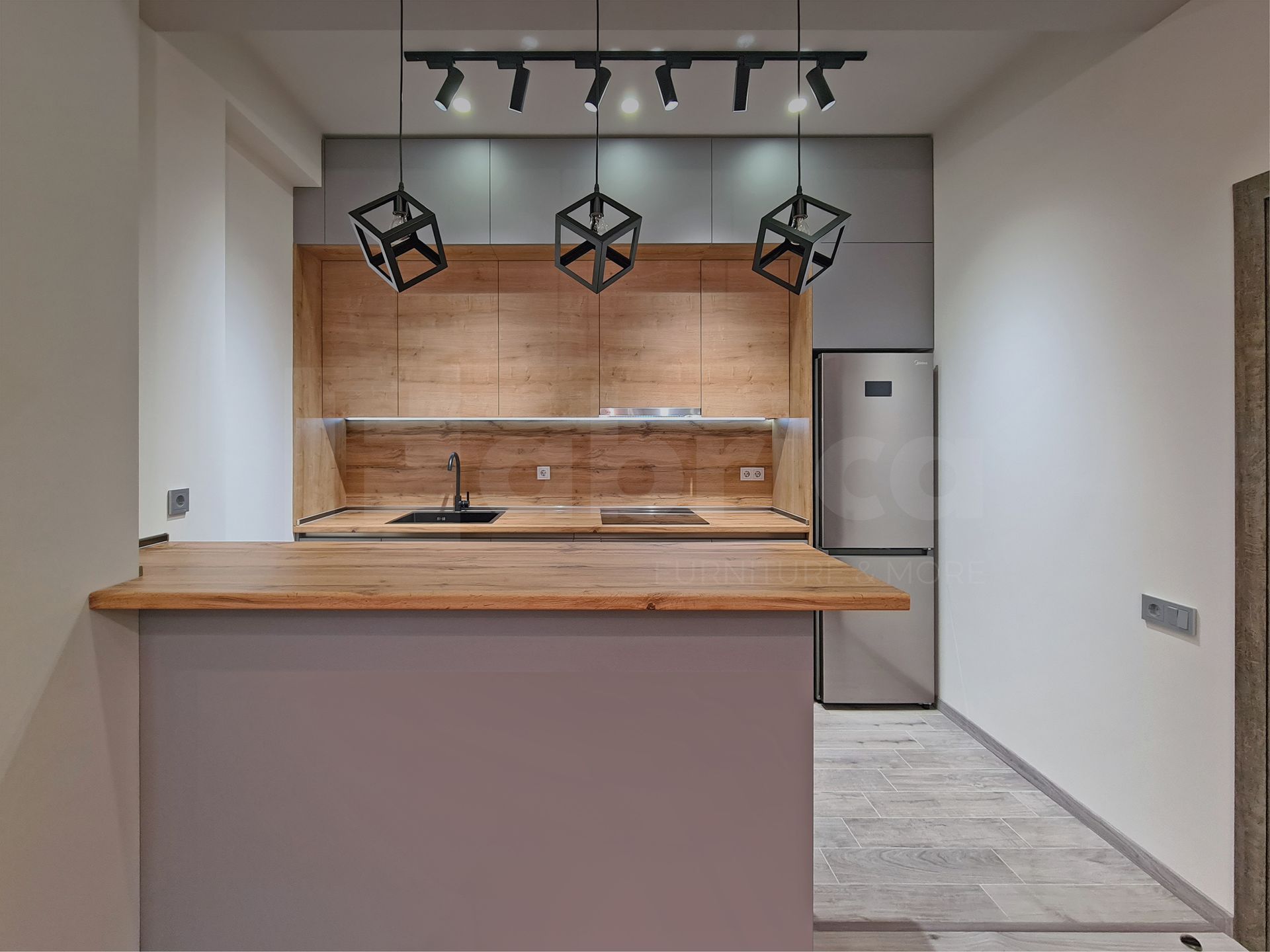 A kitchen with wooden cabinets and a stainless steel refrigerator.