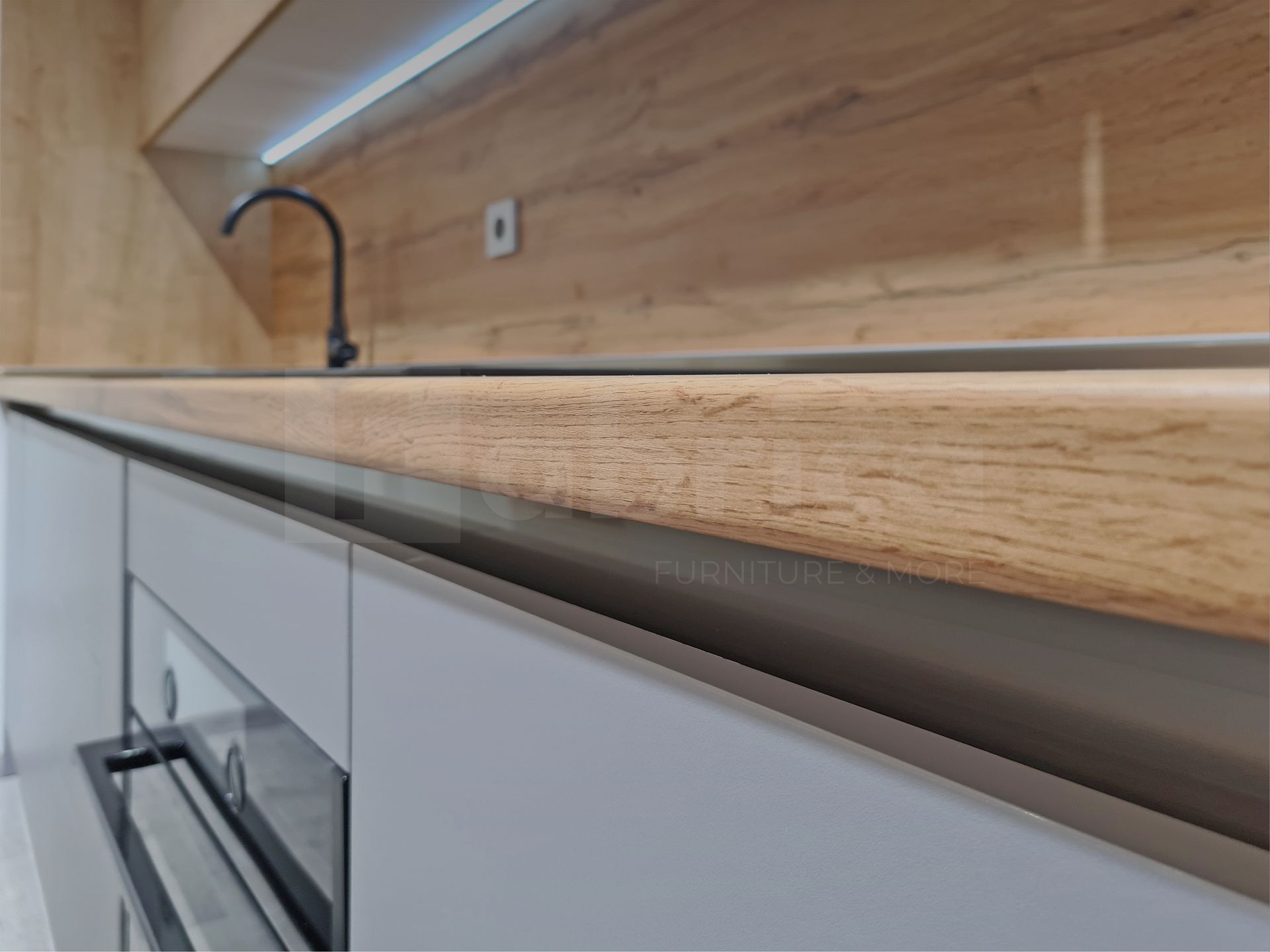 A kitchen with a wooden counter top , stainless steel appliances , and a sink.