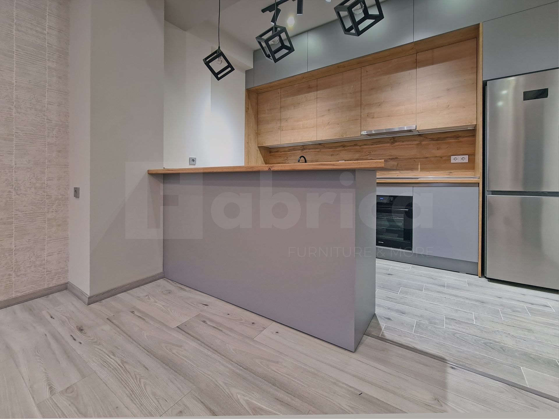 A kitchen with wooden cabinets and a stainless steel refrigerator.