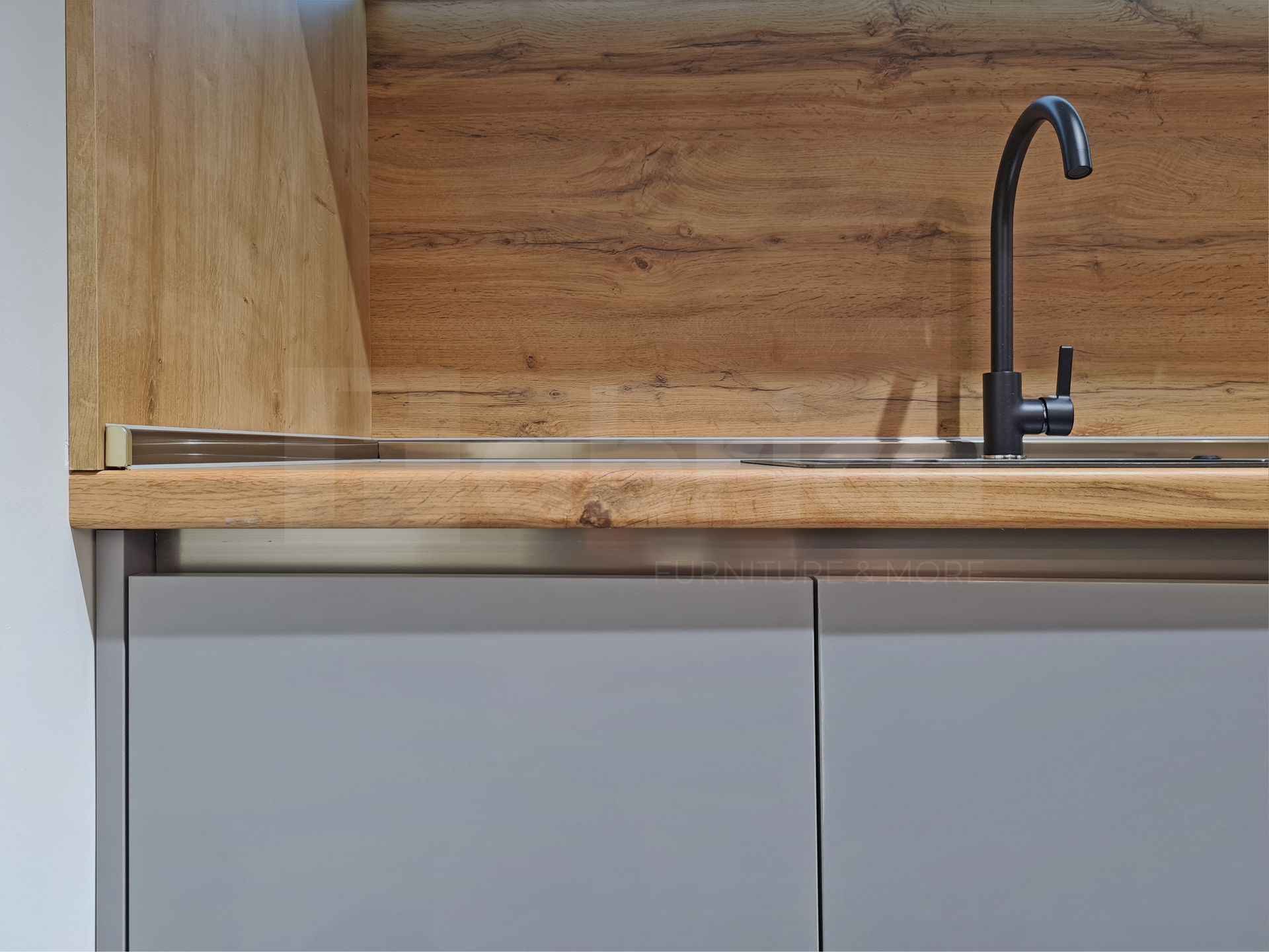 A kitchen sink with a wooden counter top and a black faucet.