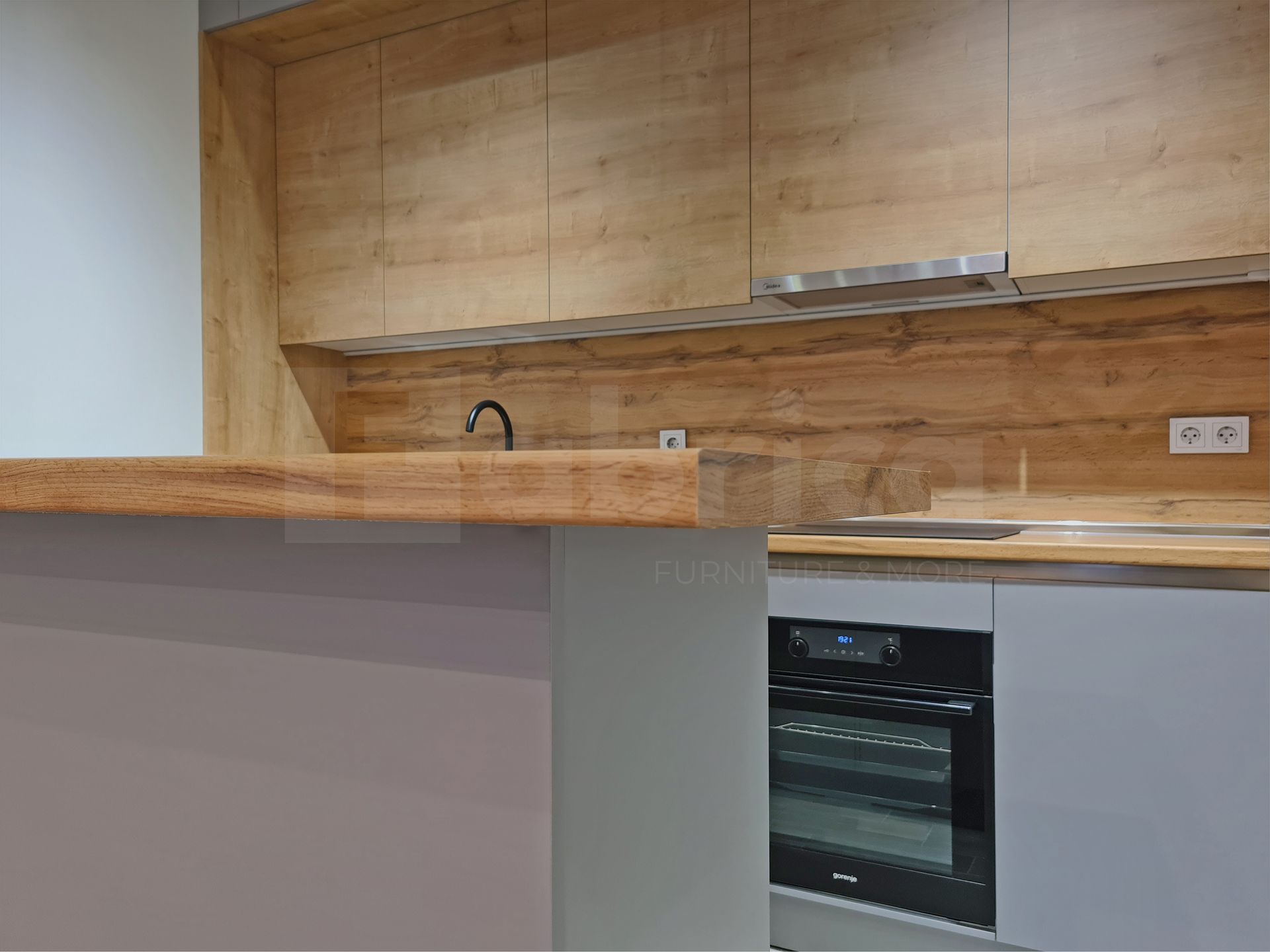 A kitchen with wooden cabinets , a sink , and an oven.