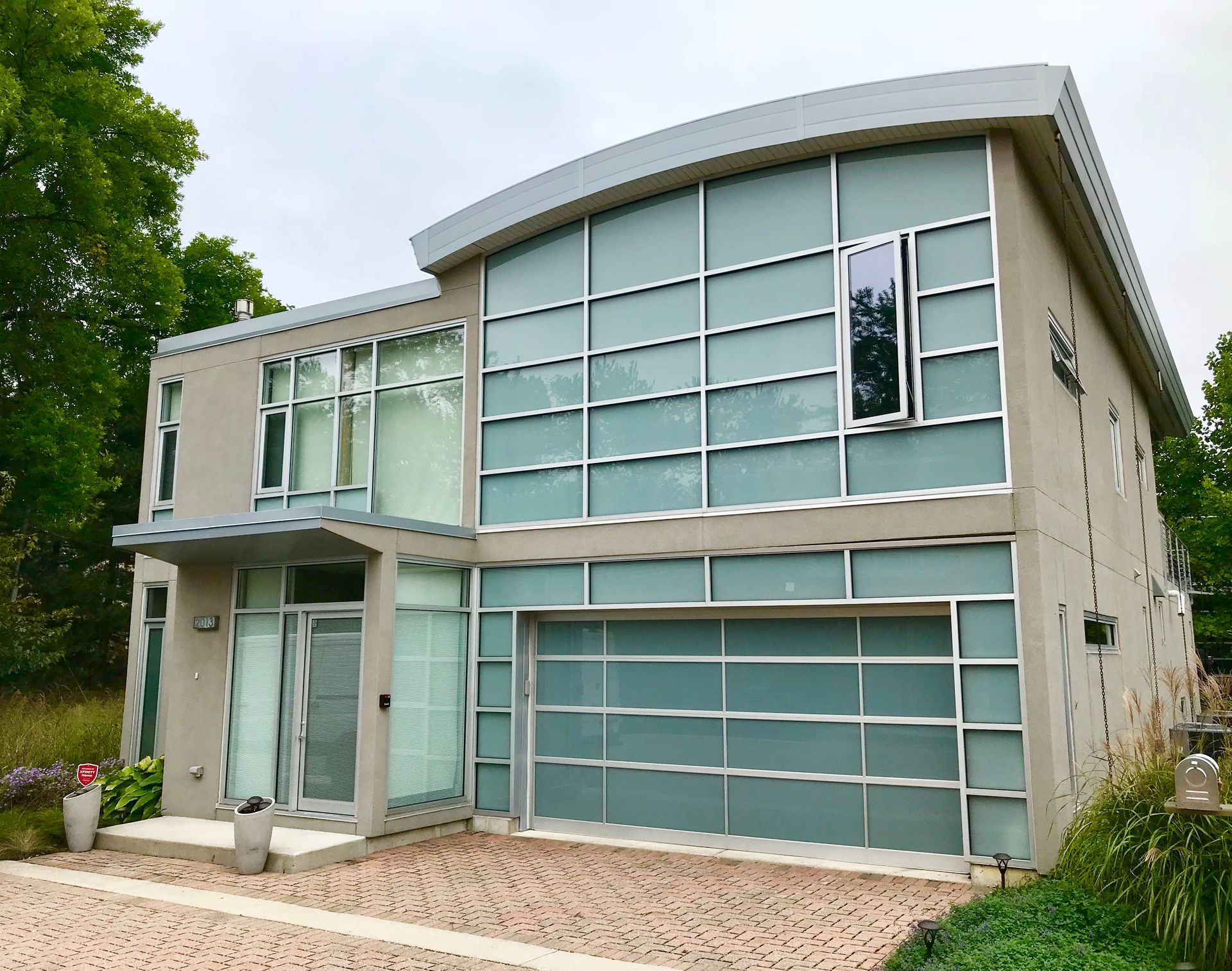 Two-story home with a white garage door, light siding, and a concrete driveway.