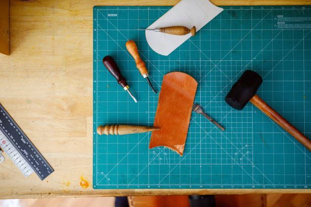 A cutting mat with tools and a piece of leather on it