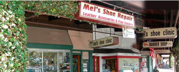 A store front with a sign that says mel 's shoe repair