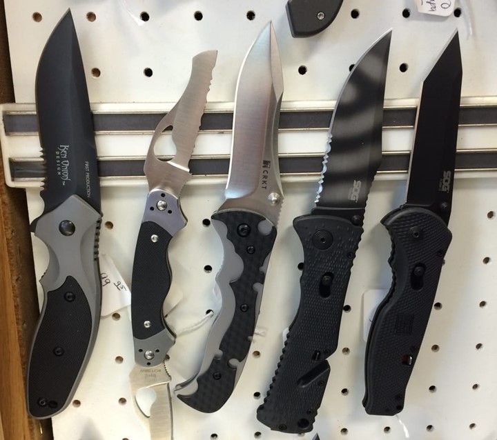 Several knives are lined up on a white board and one of the knives has the number 30 on it