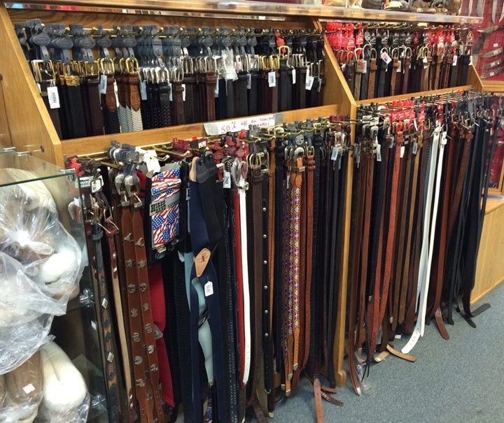 A bunch of belts are on display in a store