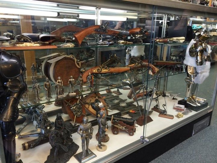 Display of historical armour and weapons in a glass case.