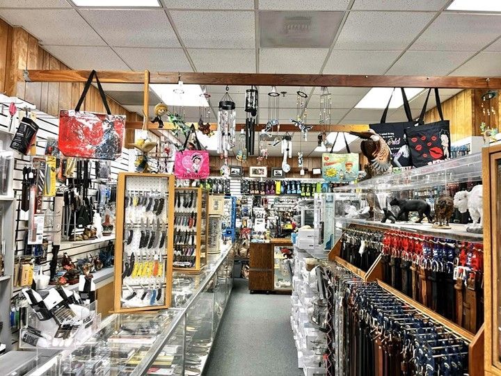 A store filled with lots of items including belts and knives.