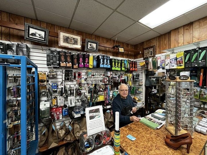 A man is sitting at a counter in a store.