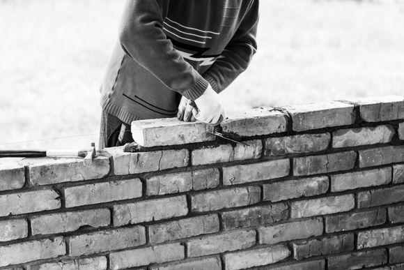 man building a brick wall