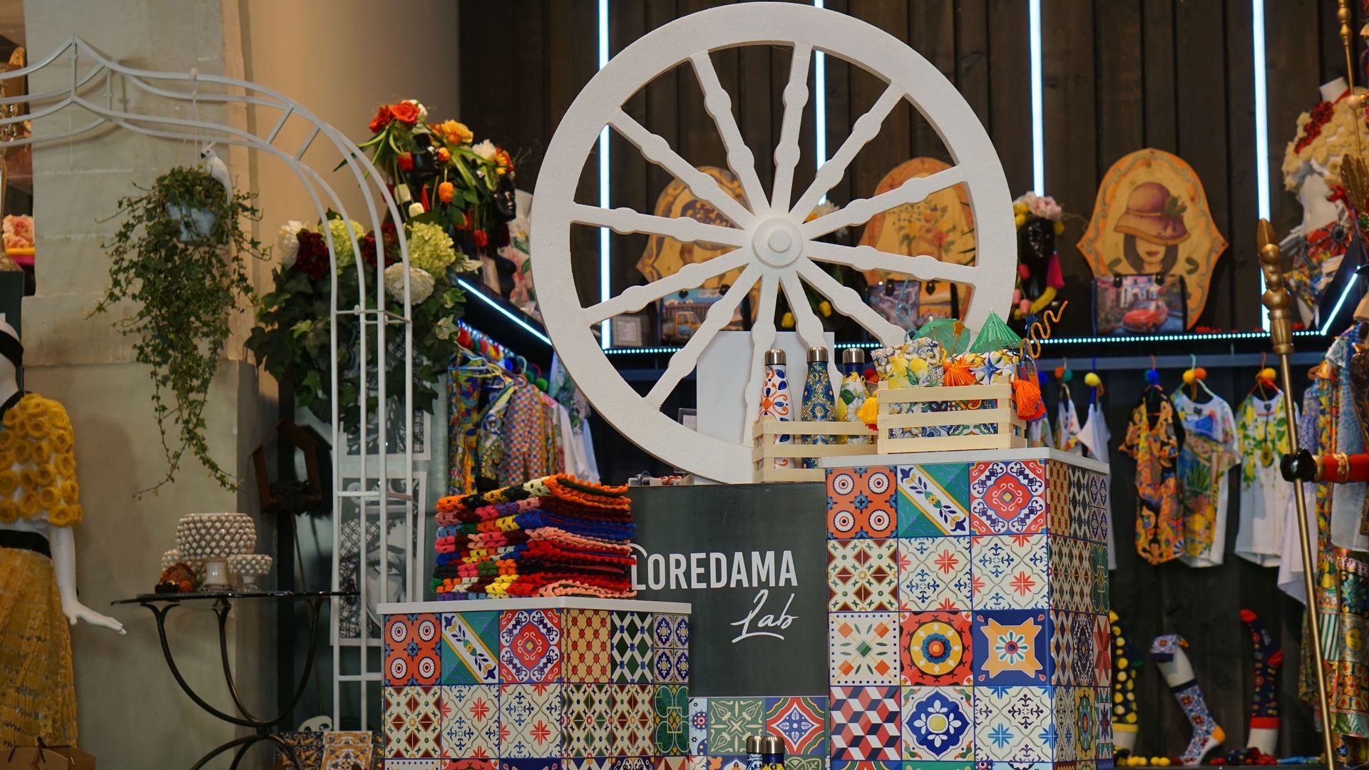 Una ruota di carro è appoggiata su un tavolo in un negozio , fasciacollo in lana colorata  fatto  a mano 