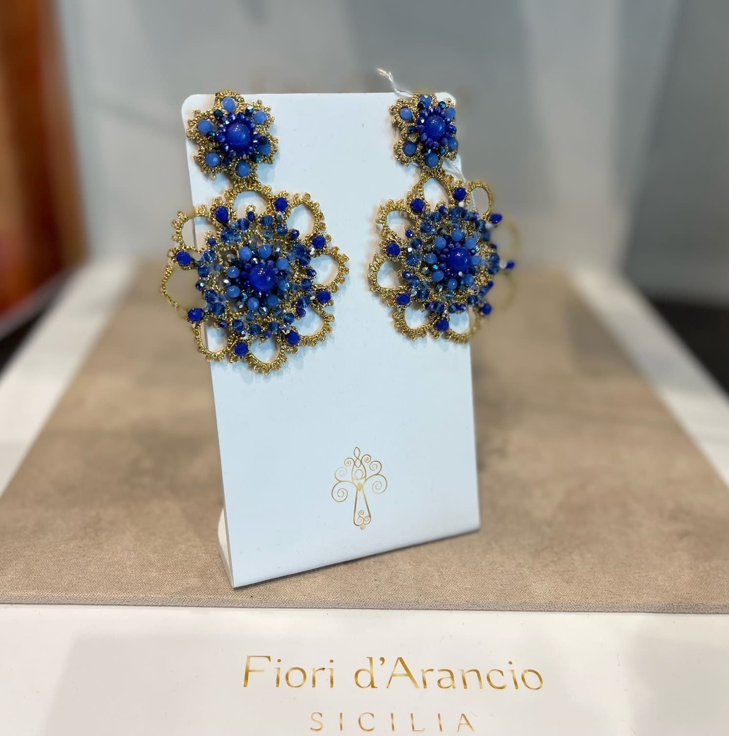 Un paio di orecchini blu e oro di fiori d'arancio 