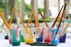 Brightly colored paint cups and brushes symbolizing custom creative work