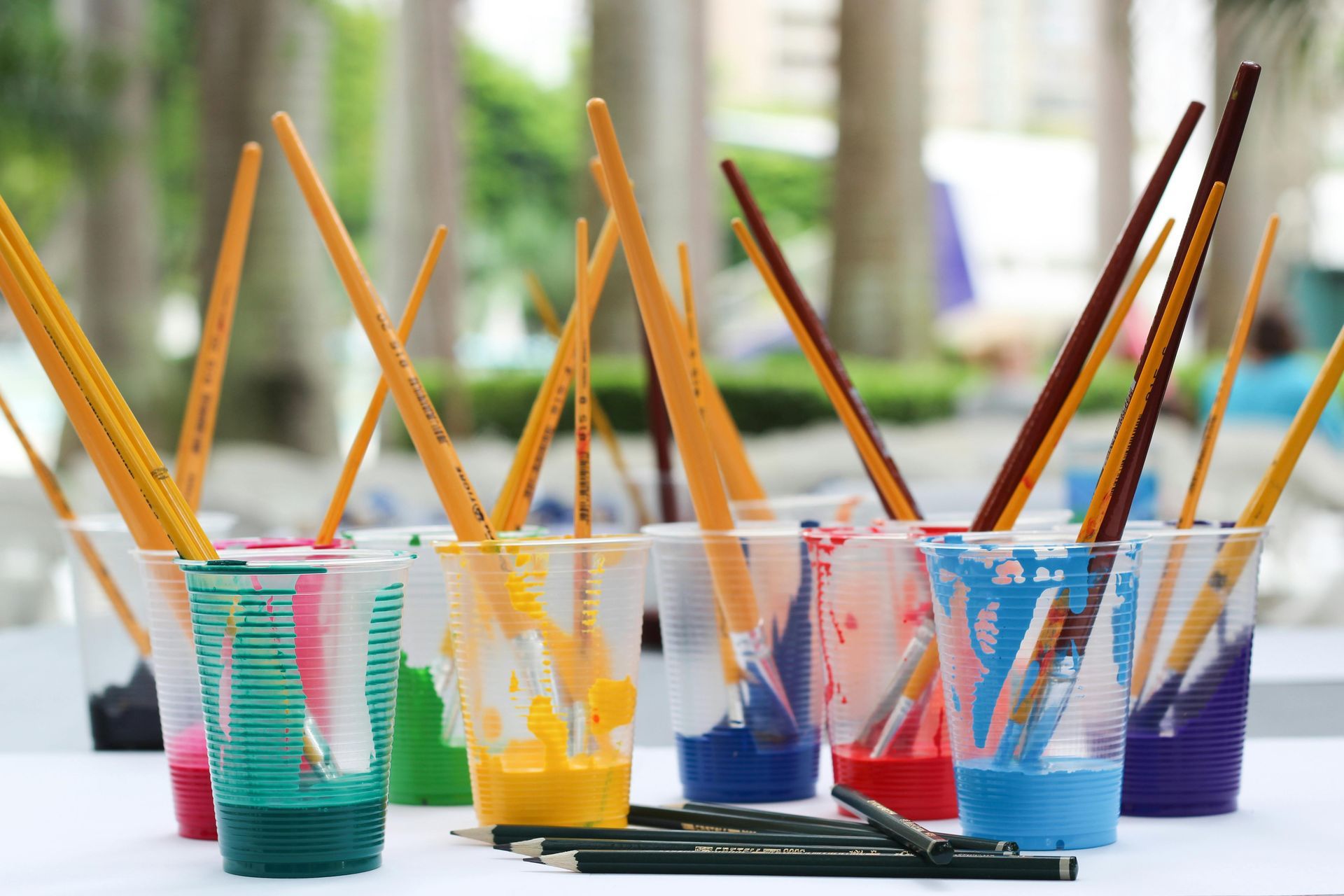 Brightly colored paint cups and brushes symbolizing custom creative work