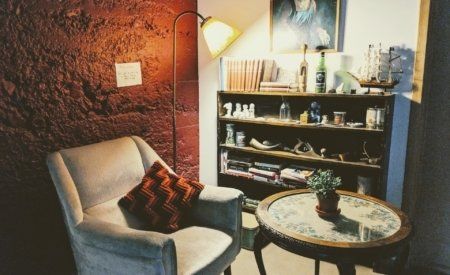 A living room with a chair a table and a bookshelf