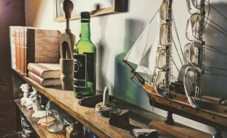 A shelf with a bottle and a model ship on it