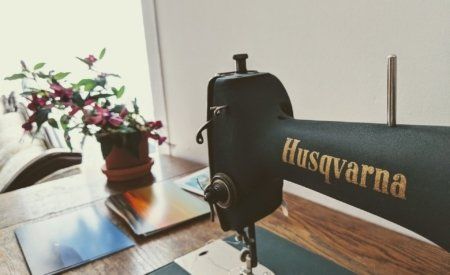 A husqvarna sewing machine is sitting on a wooden table