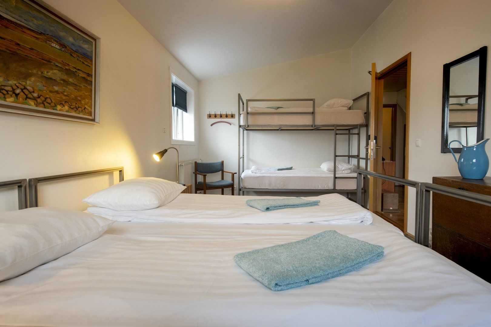 A bedroom with two beds and a bunk bed.