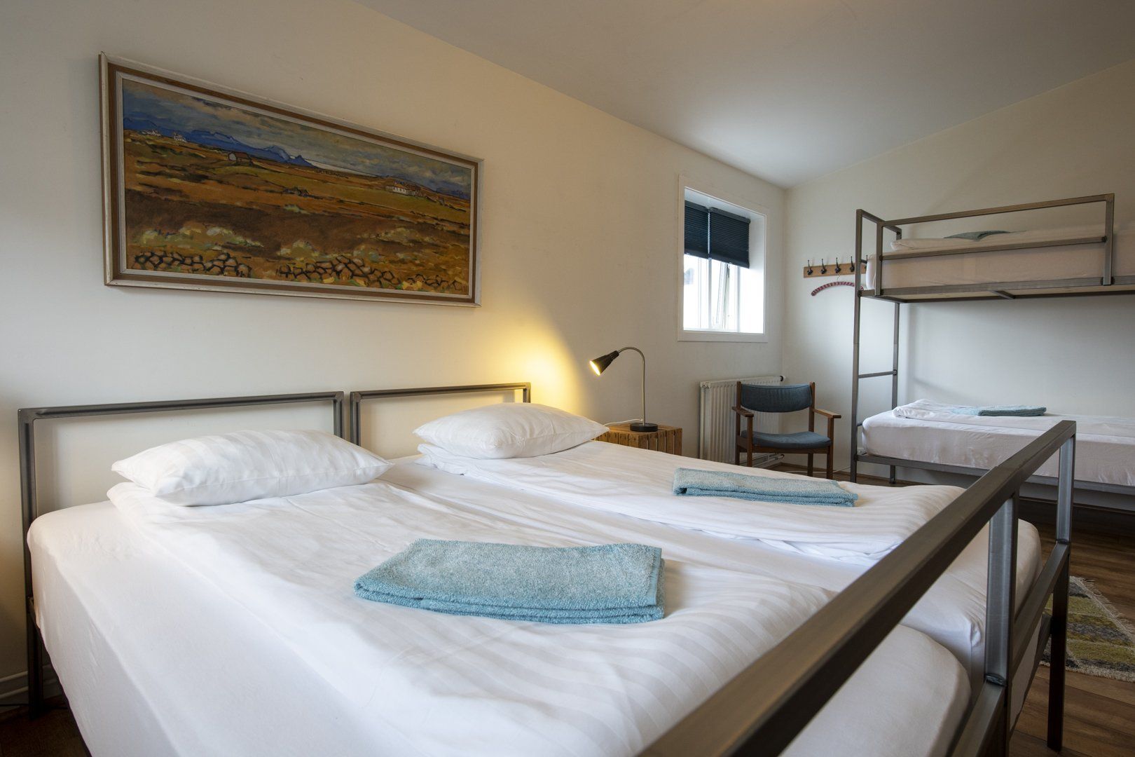 A bedroom with bunk beds and a painting on the wall