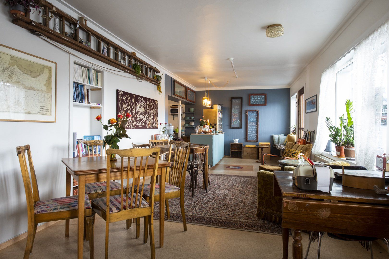 A living room with tables and chairs and a map on the wall