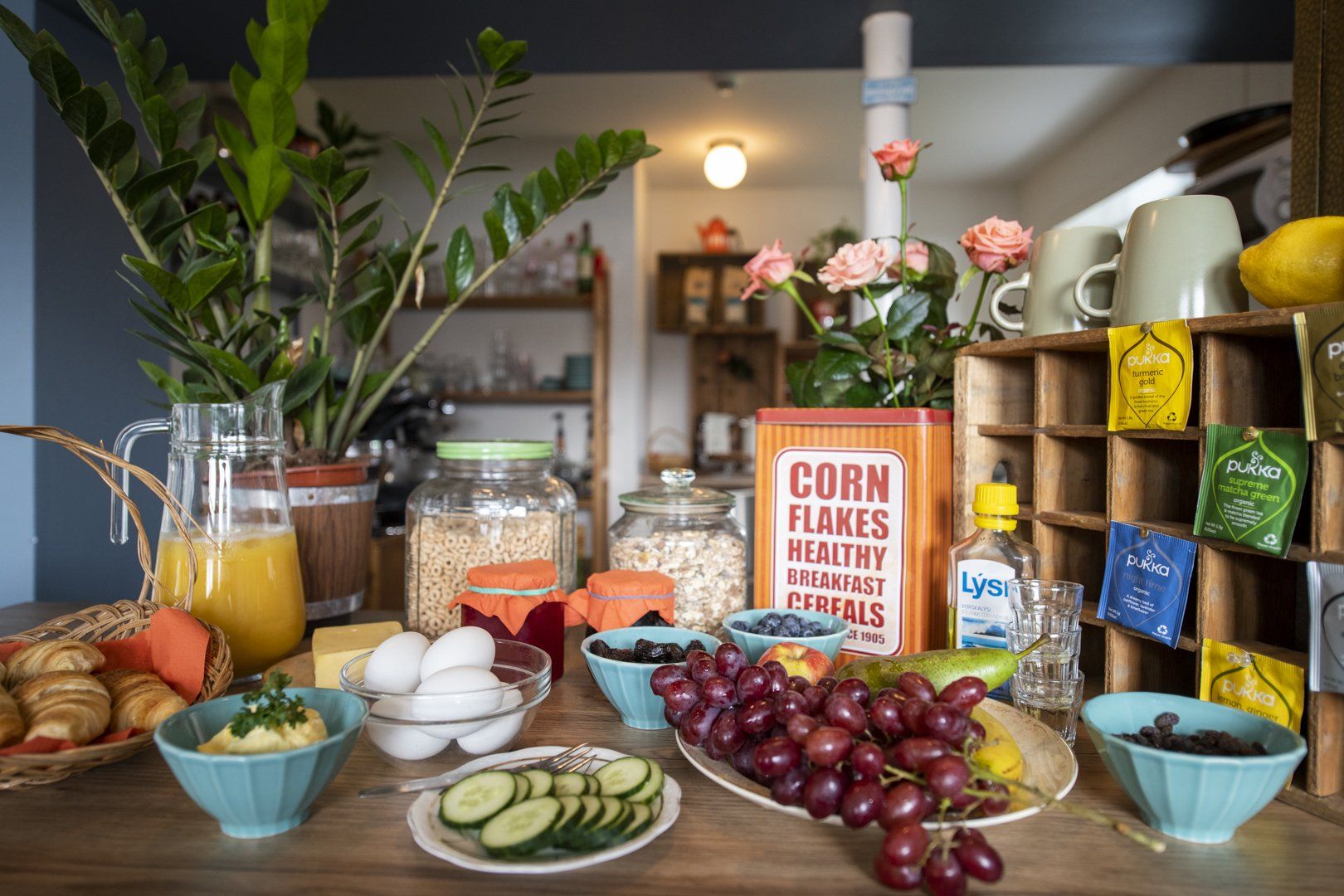 A table topped with bowls of food and a box of corn flakes.
