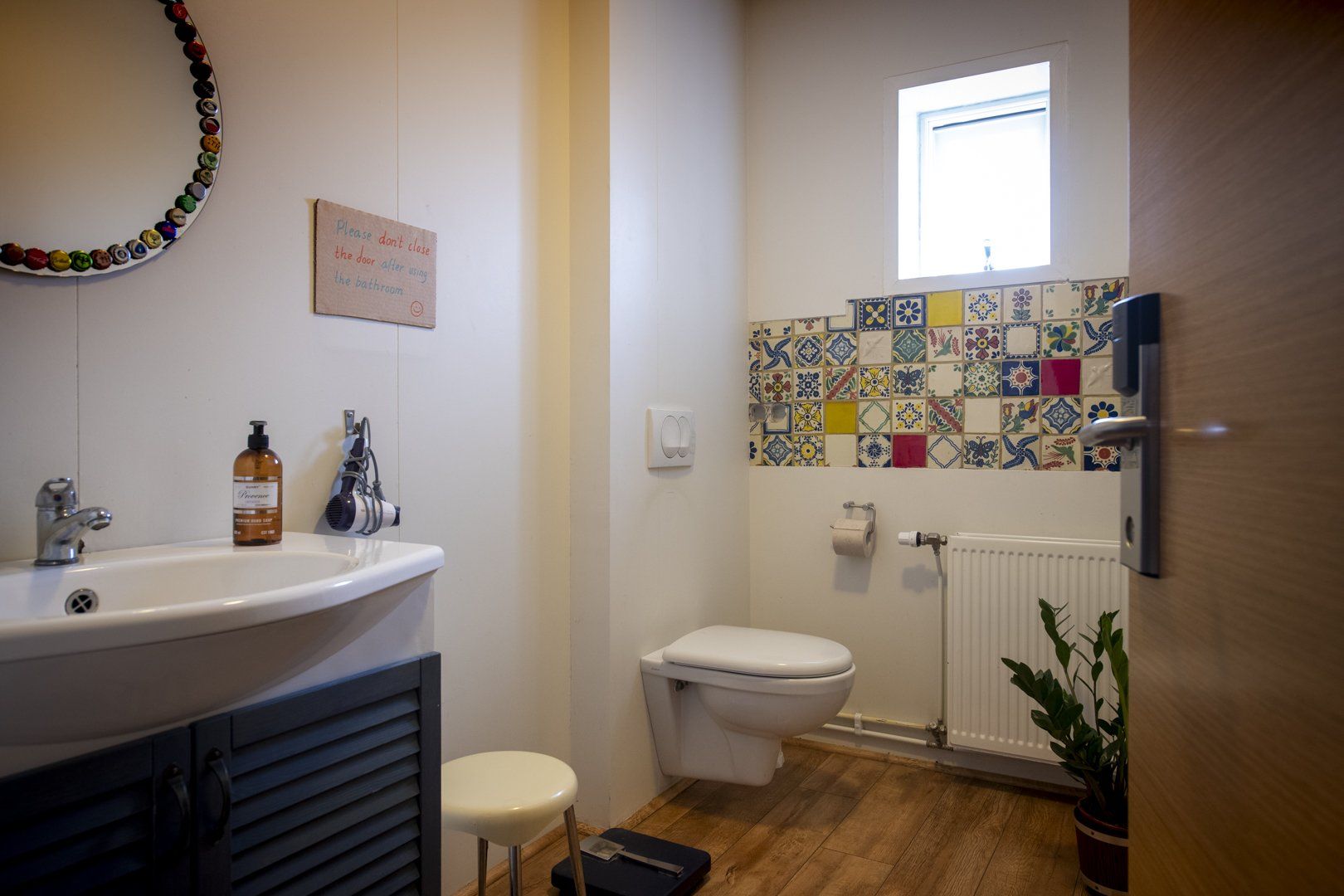 A bathroom with a sink , toilet , and window.