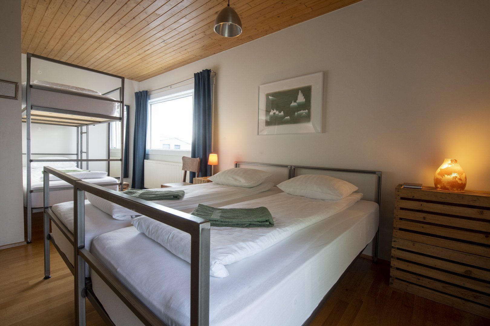 A bedroom with three beds and a bunk bed.