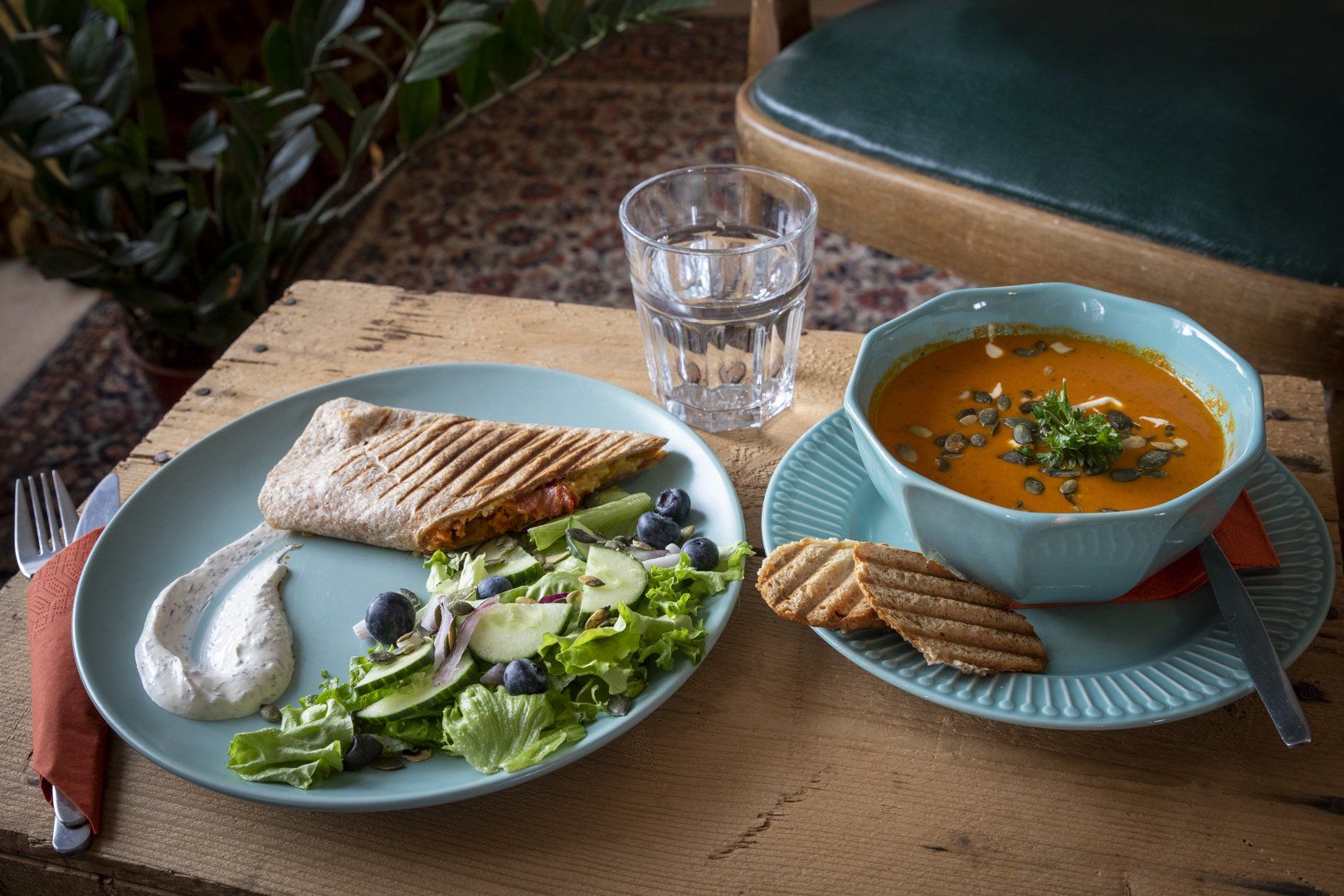 There is a plate of food and a bowl of soup on the table.