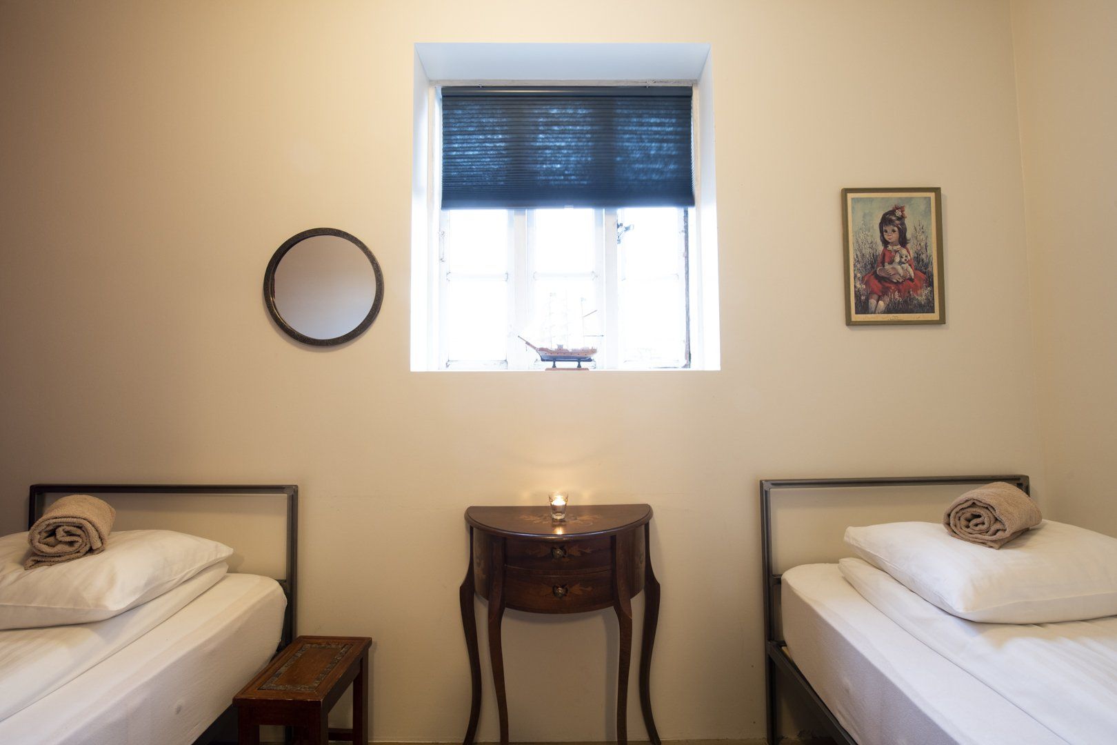 A bedroom with two beds and a mirror on the wall