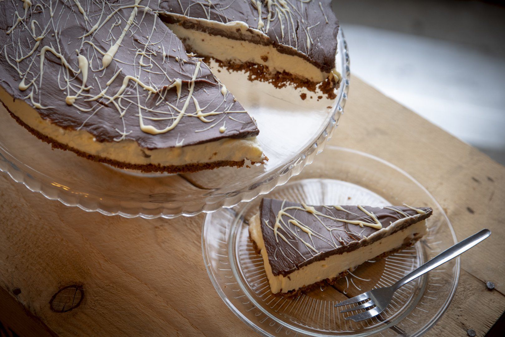 A slice of cake is on a plate next to a cake on a plate.