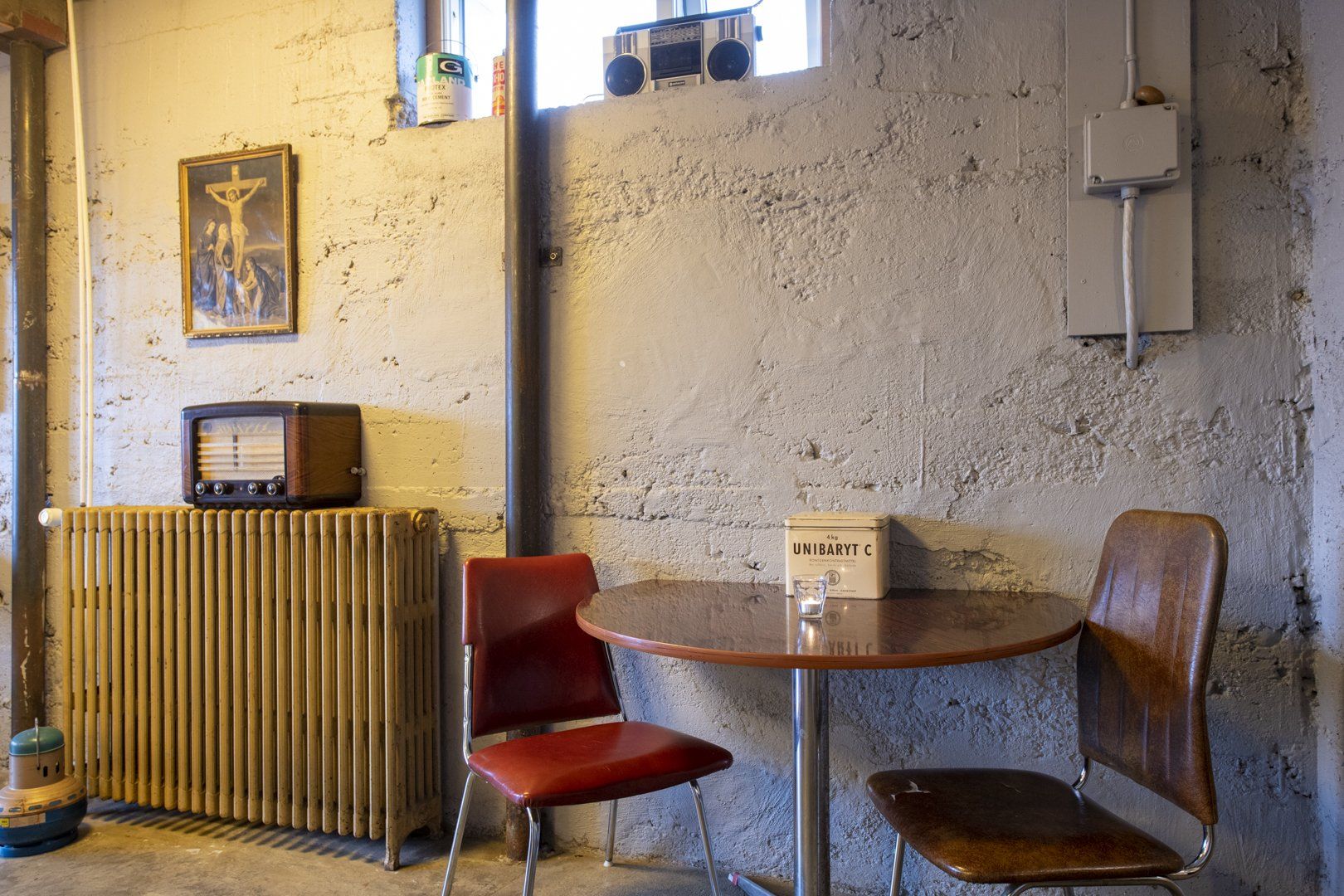 A room with a table and chairs and a radio on the wall