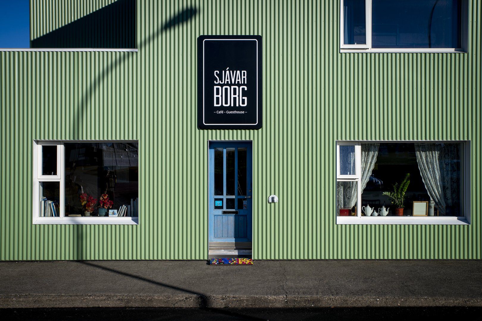 A green building with a sign that says savar borg