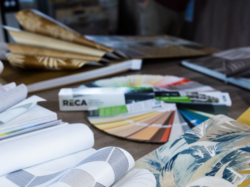 Un homme et une femme regardent des échantillons de peinture sur un mur.