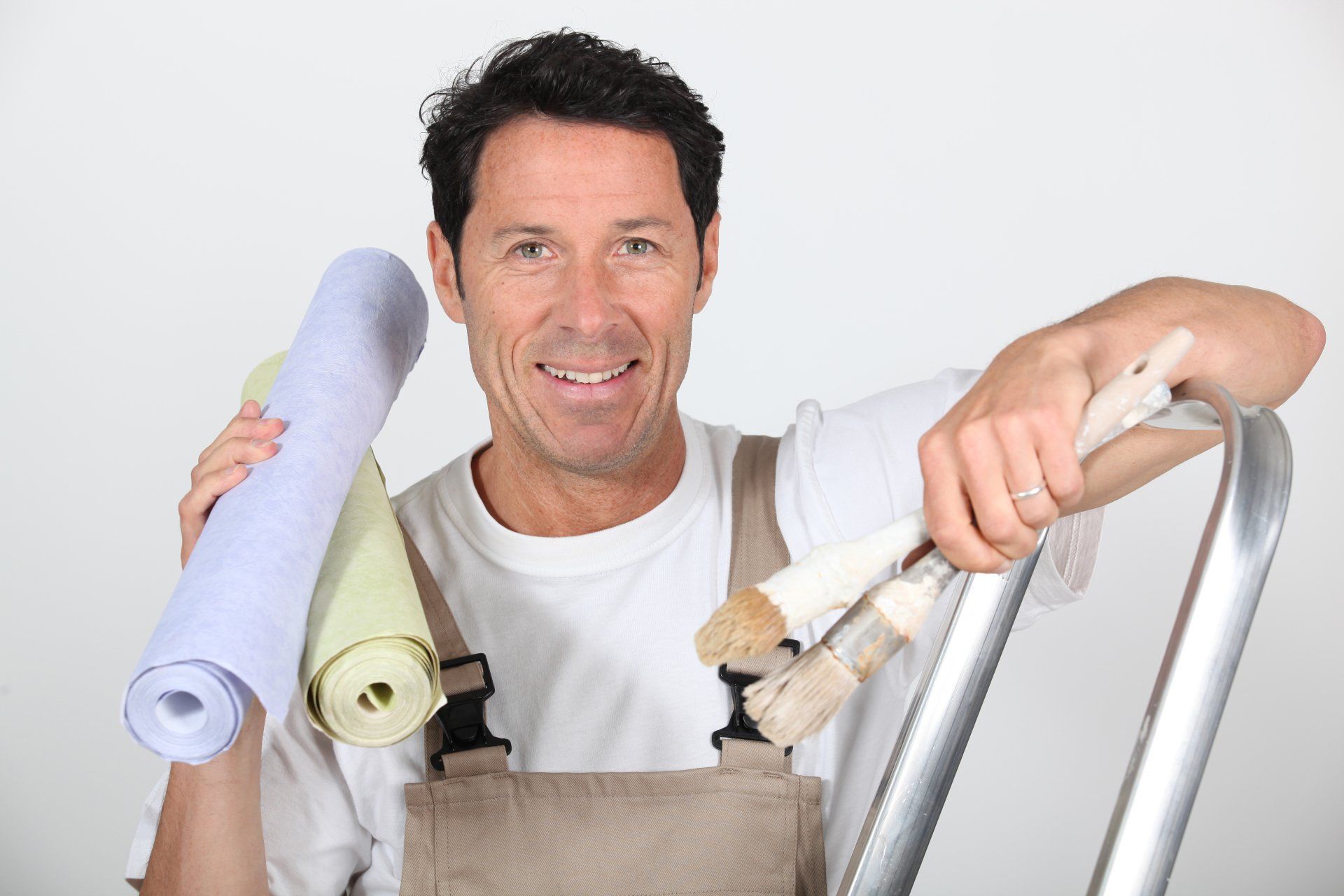 Un homme tient des rouleaux de papier peint et des pinceaux tout en s'appuyant sur une échelle.