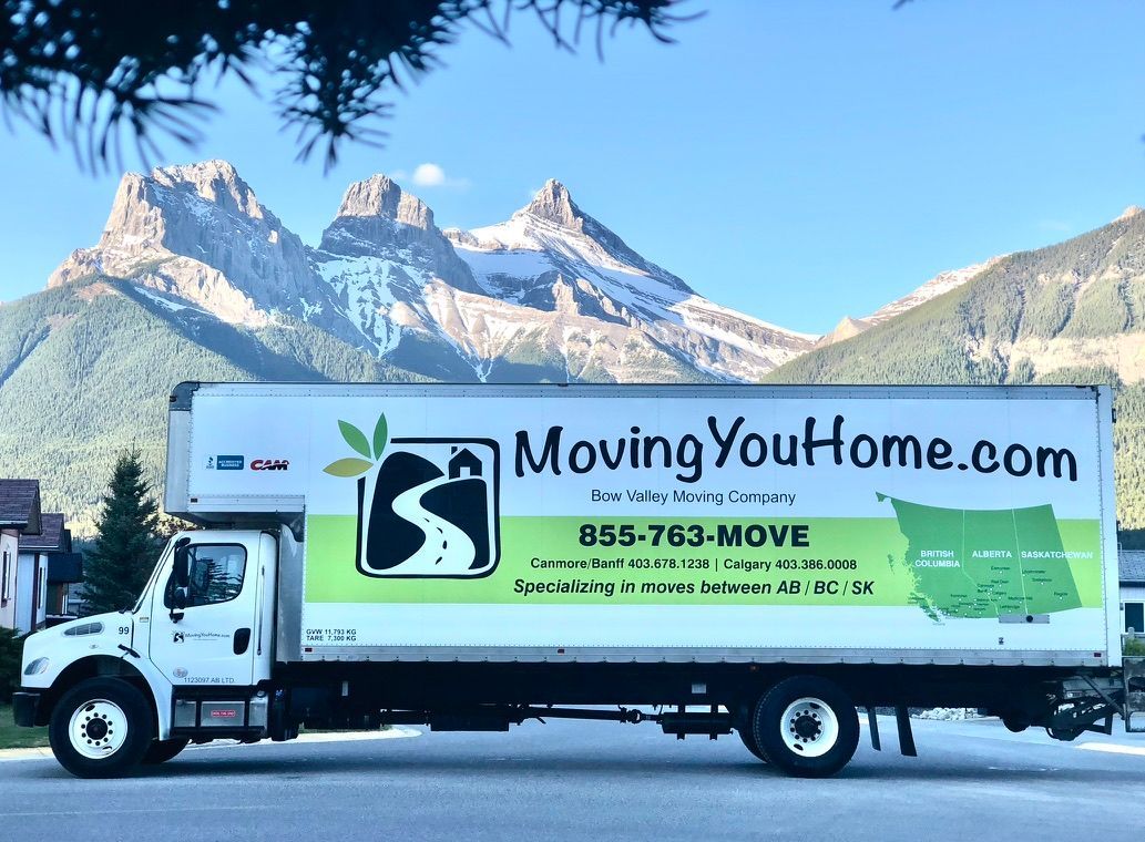 A moving you home truck is parked in front of mountains