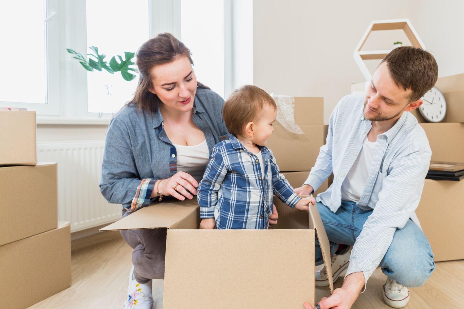 A family is moving into a new home and playing in a cardboard box.