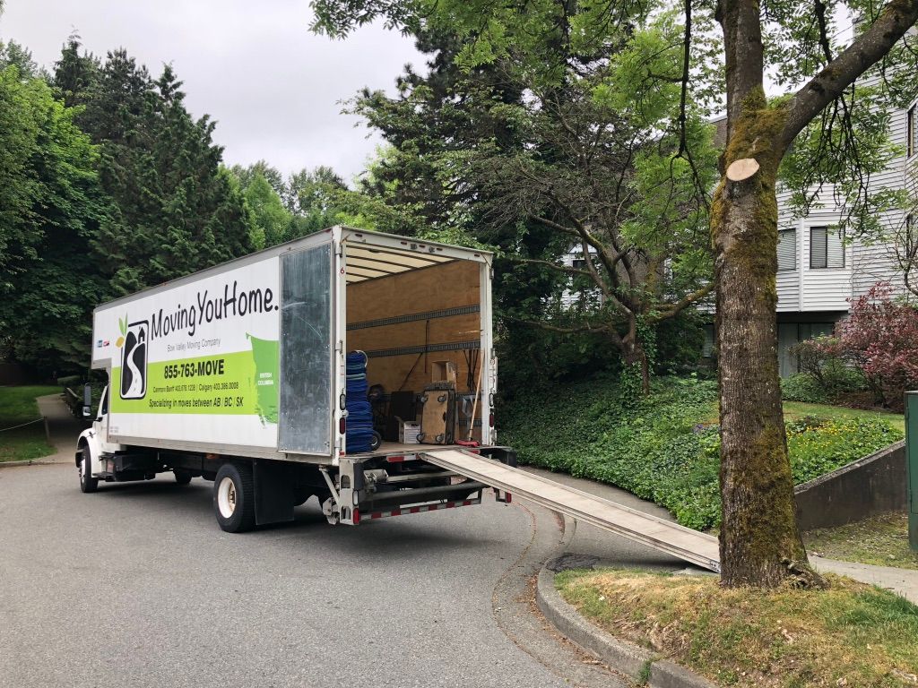 A moving truck is parked on the side of the road.