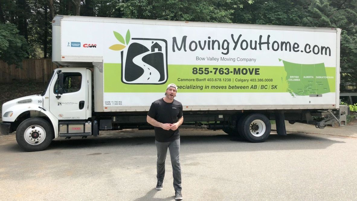 A man is standing in front of a moving truck.